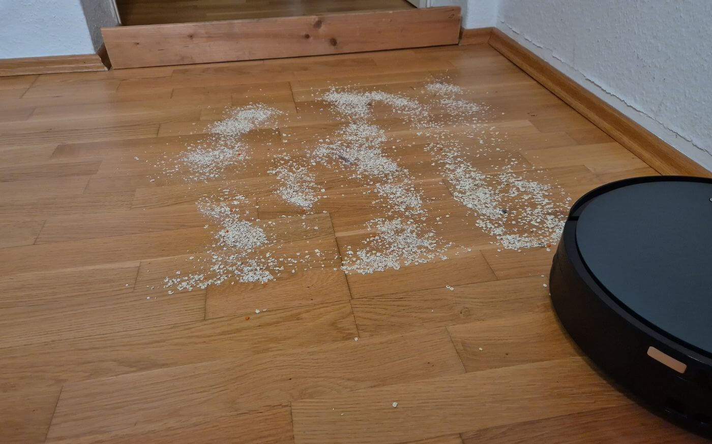 ECOVACS DEEBOT X12 OmniCyclone beim Saugtest auf Hartboden mit Haferflocken